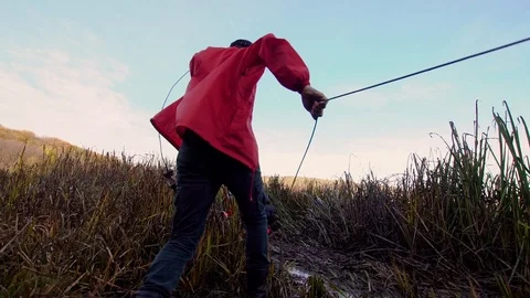 ATV off-road race.A man throws a rope to help an ATV stuck in the mud Stock Footage 104011277