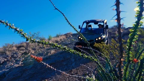 ATV Rolls Pass on Desert Hill Rising with Foliage Stock Footage 112883296