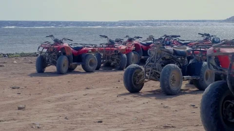 Atv by the sea, red ATVs stand by the sea, ride ATVs by the sea, red sea, atv sa 스톡 동영상 236571455