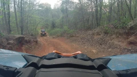 ATV side by side goes up steep peak through mud puddle then down a steep muddy Stock Footage 334100919