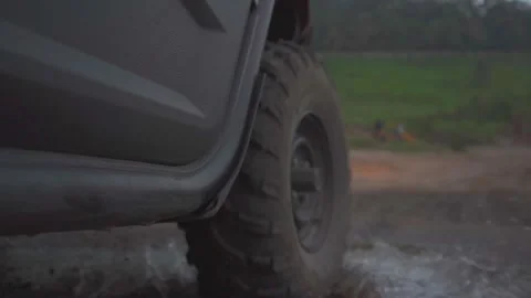 ATV Tire on Dirt Road Going Through Puddle of Water and Mud Stock Footage 293662933
