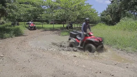 ATV's crossing a mud pond Stock Footage 88225312