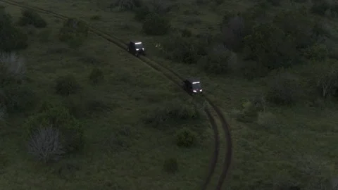 ATVs Drive Down Winding Road in the Back Country at Dusk with Bright Headlights Stock Footage 323404878