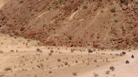 ATVs Racing Down Desert Mountain Road Stock Footage 97127101
