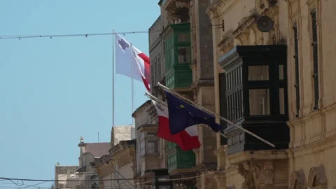 Auberge de Castille with flags shown against a sunny blue sky in Valletta Stock Footage 336488489