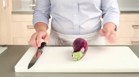 An aubergine being halved lengthways Stock-Footage 24672420