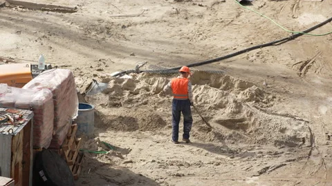 Aucasian  workers in helmets uniforms  loading sand with a shovel Stock-Footage 172262018