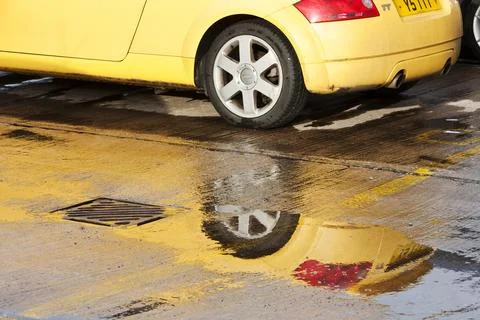 An Audi convertible reflected in a puddle. Stock Photos