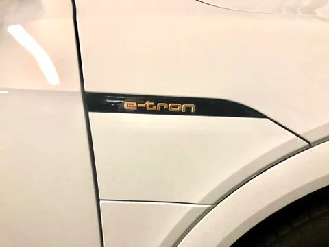 An Audi e-tron is waiting to be charged in public parking Stock Photos