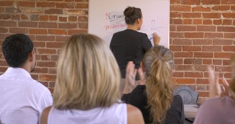 Audience applauding at a business presentation when a woman is writing Stock Footage 88355916