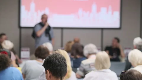 Audience attending presentation with speaker at community event discussing Stock Footage 310803437