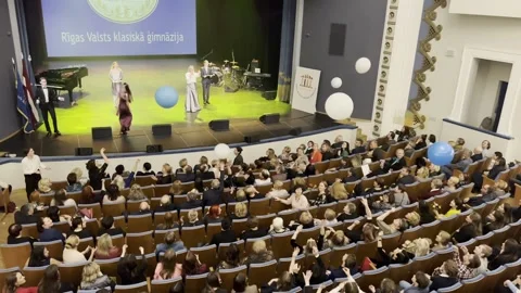 The audience in the concert hall throws huge balls. Stock Footage 236925742