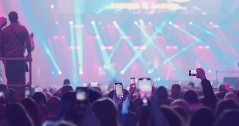 Audience crowd on bright stage lights backdrop at music festival. Happy fans Stock Footage 266483558
