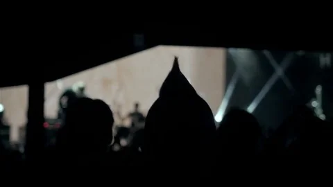 Audience with hands raised at a music festival and lights streaming down from Stock Footage