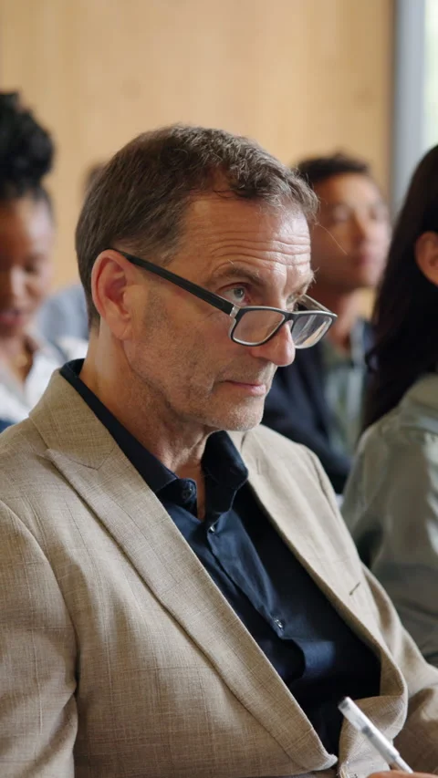 Audience, man and listening with notes in seminar for finance expo, knowledge or Stock Footage 334042210