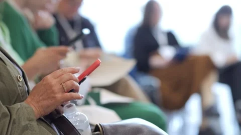 Audience member writes notes, others check devices Stock Footage 340946842