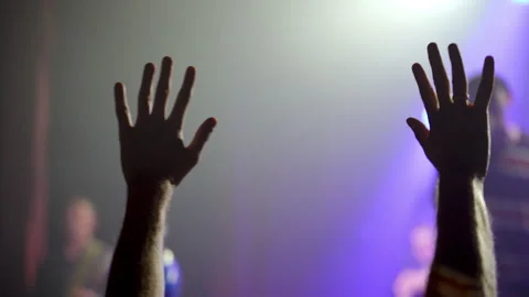 Audience raising hands and gesturing at concert with purple lights Video stock 312683042