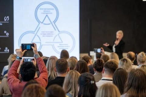 Audience recording keynote presentation at business conference, people using Stock Photos