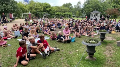 Audience watching H C Andersen show in the Fairy-tale Garden in Odense Centre Video stock 201998596