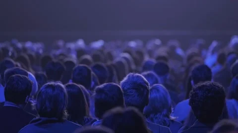 Audience watching performance in dark theater, blue stage lighting and focused Stock Footage 336352922