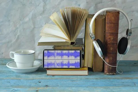 Audio book concept with stack of books, headphones,smartphone, waveform Stock Photos