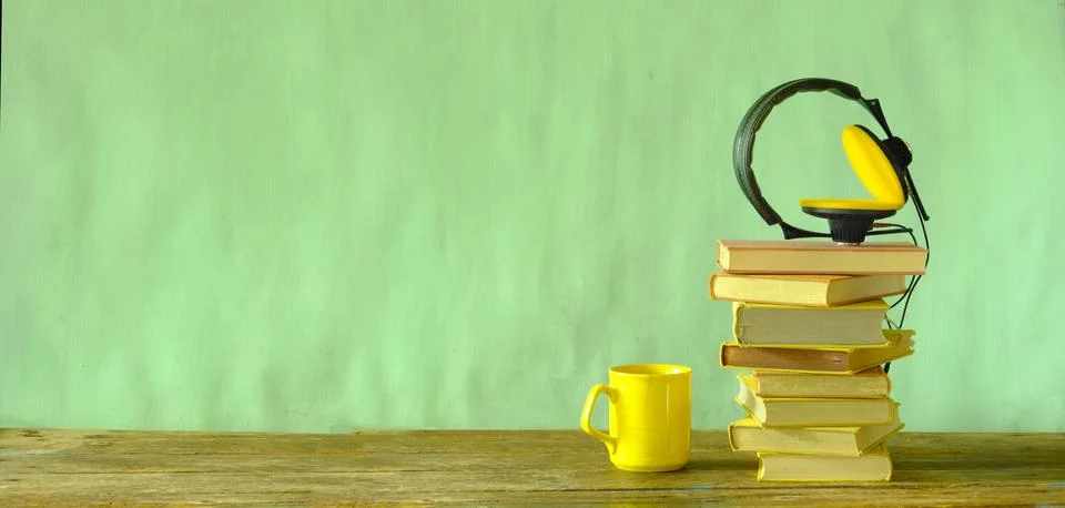 Audio book concept with stack of books and vintage headphones green back Stock Photos