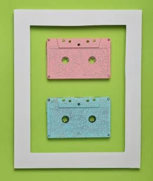Audio cassettes from 80s in a white frame on a colored green background. Mini 库存照片