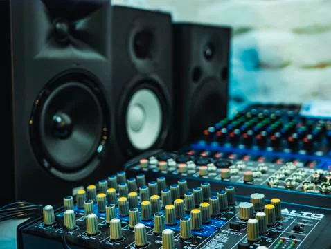 Audio controller with knobs, speakers on the background. Stock Photos