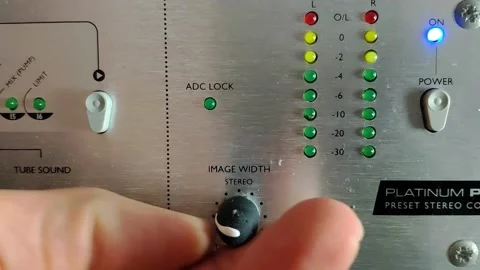 An audio device with knobs and vertical LED level meters. These turn on 動画素材 145114634