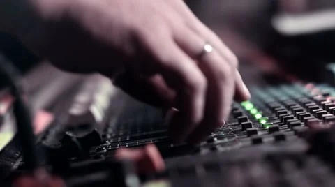 Audio Engineer adjusting faders on his mixing console desk during a live event. Stock Footage 52056586
