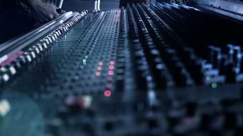 Audio Engineer adjusting knobs and faders on his mixing console desk during a Stock Footage 52056536