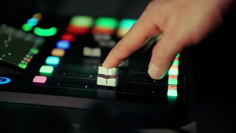 Audio engineer hand adjusting silver faders mixing console studio Stock Footage 332589723