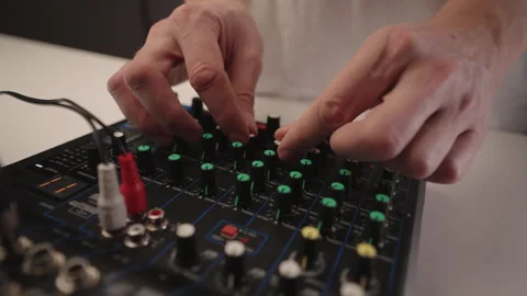 Audio engineer hands working on compact sound mixer, manipulating various Stock Footage 324865766