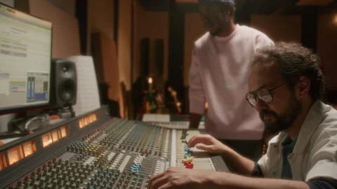 Audio Engineer Mastering Tracks with Music Artist in Recording Studio Stock Footage 334364115