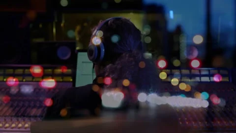Audio engineer placing headphones on head at console, responding to monitor cue, Stock Footage 330981067
