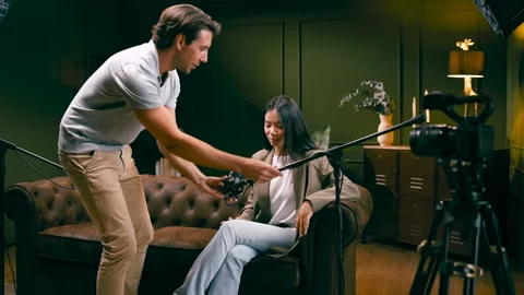 Audio engineer preparing a microphone for an interview podcast Stock Footage 341483381