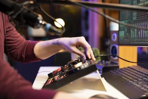 Audio engineer twisting pre amp knobs to edit tunes in post production Stock Photos