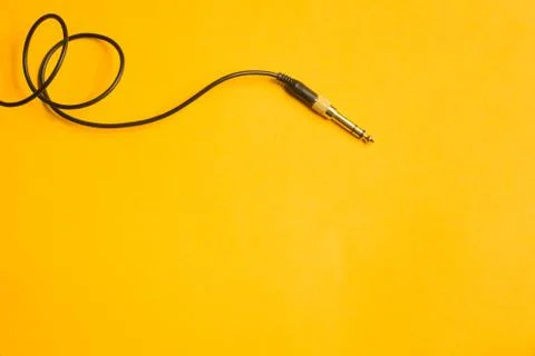 Audio jack with black cable isolated on yellow 写真素材