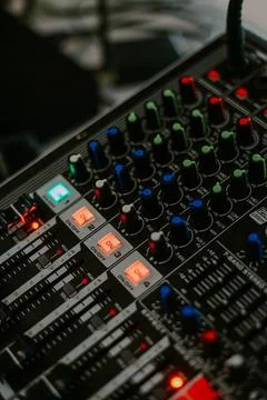 Audio mixer soundboard with various knobs, sliders, and indicator lights Stock Photos