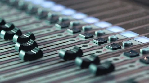 Audio mixer in a studio, the automatic knobs moving up on console. Close-up DOF Stock Footage 76908169