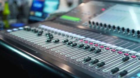 Audio mixer in a studio, the automatic knobs moving up on console. Close-up DOF Stock Footage 76910123