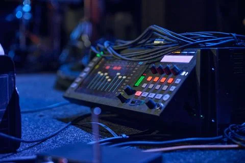 Audio mixing console controls stage sound under blue concert lighting Stock Photos