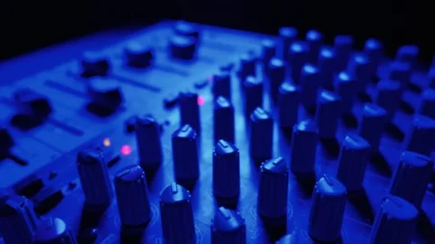Audio Mixing Console Knobs and Faders in Blue Studio Lighting Stock Footage 334737082