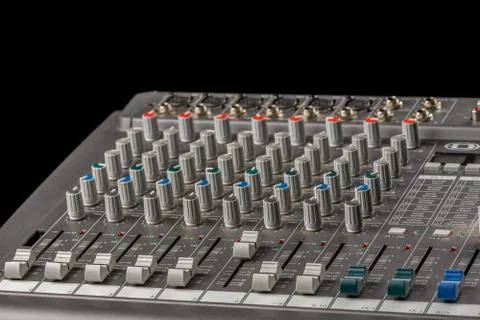 Audio mixing console with knobs and sliders and black background Stock Photos