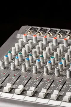 Audio mixing console with sliders and knobs on the channels. Stock Photos