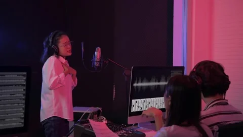 Audio recording concept of 4k Resolution. A young Asian singer is recording i Stock Footage 145321548