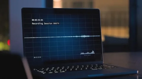 Audio sound wave recording software on a laptop screen at night on office desk Vídeos de archivo 333048500
