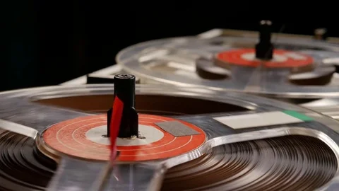 Vintage Reel to Reel tape recorder playing music close up of reel