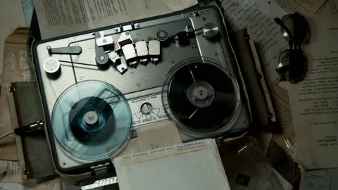 Audio tape records on table covered in documents as room light blinks, Stock Footage 156181769