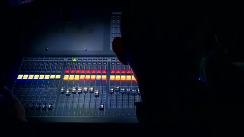 Audio technician working on soundboard in the dark production booth. Stock Footage 144430883